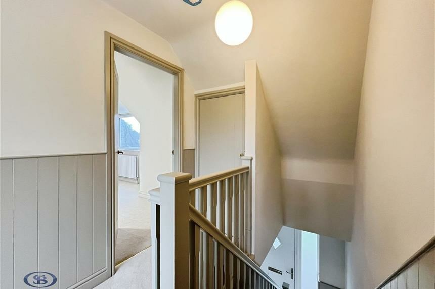 Landing with panelled walls and oak staircase