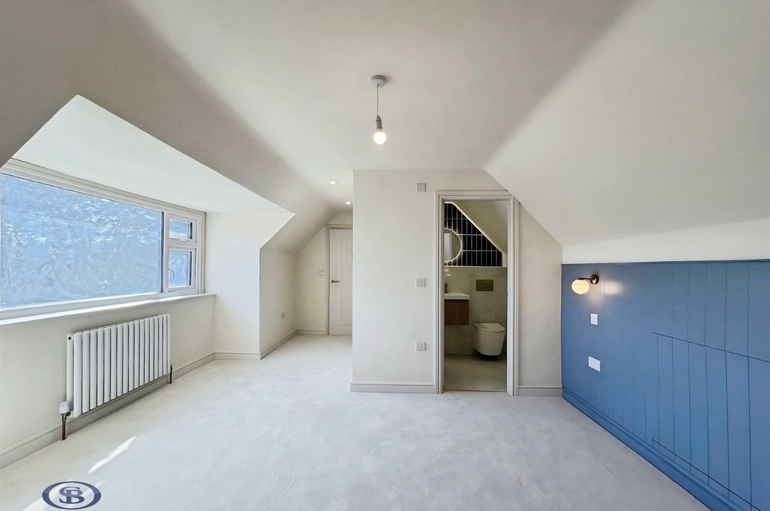 Dormer bedroom with blue panelling and en suite