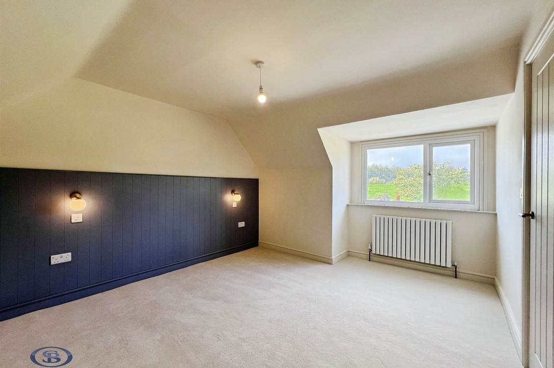 Bedroom with panelled feature wall and field views