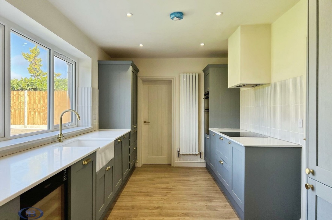 Galley kitchen with shaker units and brass handles