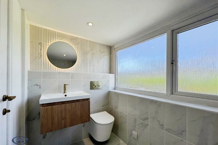 WC with fluted vanity and backlit mirror