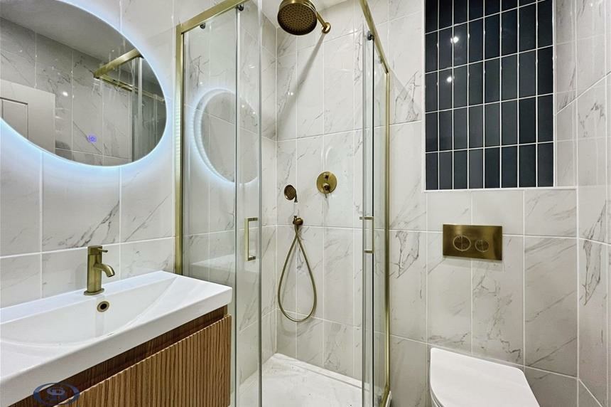 Shower room with brass fittings and marble tiling