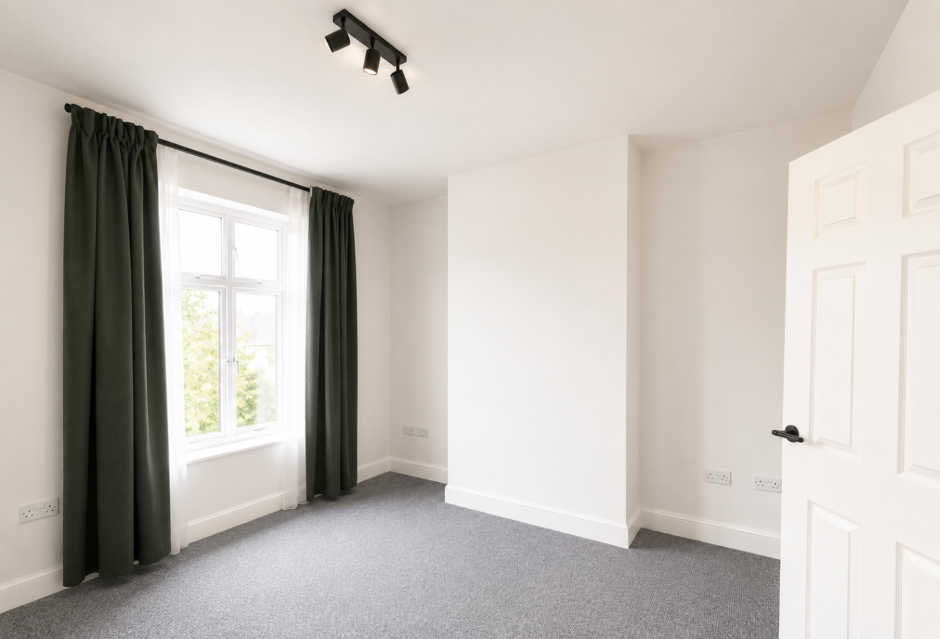Finished bedroom with window, soft carpeting and clean white walls
